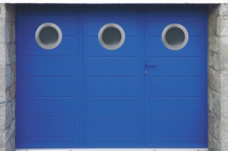 Porte de garage battante pliante bleue avec portillon et hublots ronds à Quint-Fonsegrives